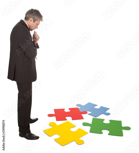 Foto: Senior businessman assembling a jigsaw puzzle Senior businessman assembling a jigsaw puzzle
