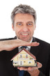 Businessman holding model of a house in hands