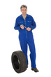 Automechanic standing next to car tire