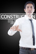 Businessman pushing Construction word on the whiteboard.