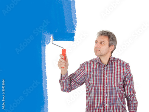Foto: Senior adult painting wall in blue Senior adult painting wall in blue