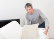 Senior man moving sofa