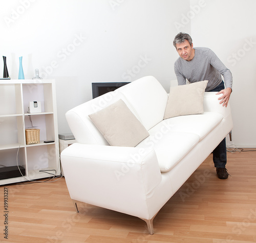 Foto: Senior man moving sofa Senior man moving sofa