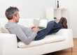Senior man sitting in sofa and using laptop