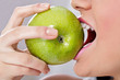 Photo: Woman biting green apple Woman biting green apple