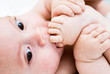A little boy sucking toes on her feet