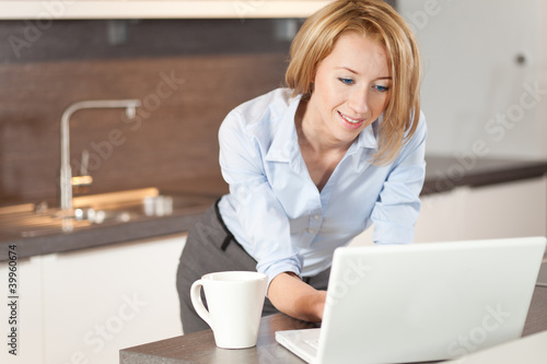 Photo: Frau mit laptop in der Küche Frau mit laptop in der Küche