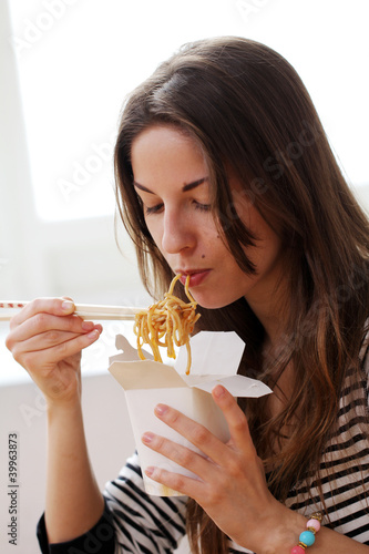Photo: Happy woman eating noodles Happy woman eating noodles