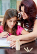 Latin girl studying with her mother