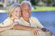 Happy Senior Couple Sitting On Park Bench Laughing