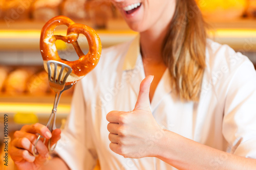 Photo: Salesperson is packing bread in bakery Salesperson is packing bread in bakery