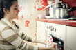 Woman taking frying pan from oven