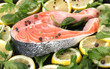 Red fish with lemon, parsley and pepper on plate close up.