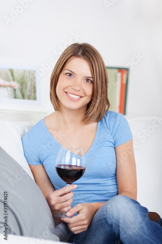 Foto: entspannte frau mit weinglas auf dem sofa entspannte frau mit weinglas auf dem sofa