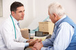 American doctor talking to senior man in surgery