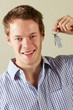 Studio Shot Of Young Man Holding Keys To First Home
