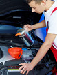 Young motor mechanic doing an oil change in a garage
