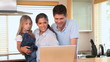 Couple with little girl using a laptop