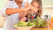 Mother and daughter mixing the salad