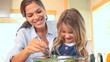 Video: Little girl mixing salad with her mother Little girl mixing salad with her mother
