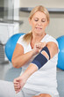 Seniorin mit Bandage am Ellenbogen