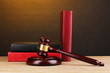 Judge's gavel and books on wooden table on brown background Judge's gavel and books on wooden table on brown background