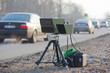 speed camera at the side of the road with blurred car passing