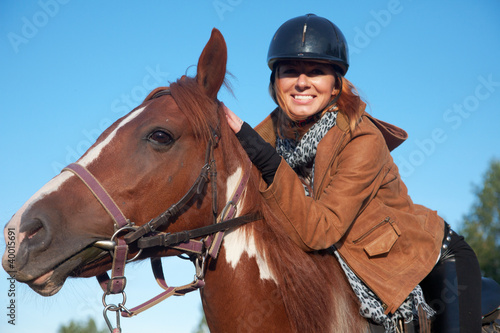 Photo: A woman riding a horse A woman riding a horse
