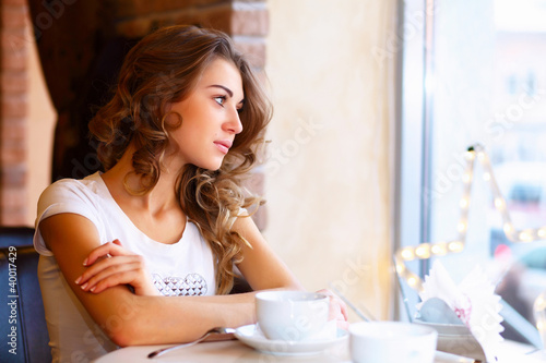 Photo: Young pretty woman sitting in restaurant Young pretty woman sitting in restaurant