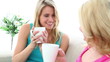 Two blonde friends drinking a coffee together