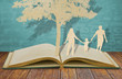 Paper cut of family symbol under tree on old book