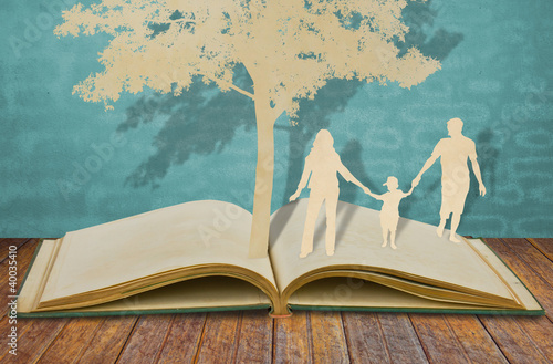 Photo: Paper cut of family symbol under tree on old book Paper cut of family symbol under tree on old book