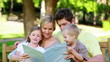 Video: Family looking a picture book on a bench Family looking a picture book on a bench