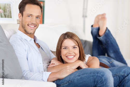 Photo: entspanntes junges paar liegt auf dem sofa entspanntes junges paar liegt auf dem sofa