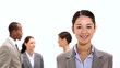 Smiling businesswoman with co-workers behind her