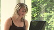Junge Frau arbeitet am Computer am Fenster