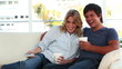 Smiling couple relaxing while watching the television