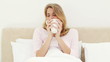 Smiling blonde woman drinking a coffee