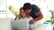 Cheerful couple looking at a laptop