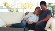 Couple laughing while watching the television