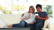 Happy couple watching the television together