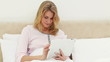 Smiling blonde woman using an ebook
