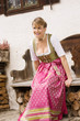Bayerisches Mädchen in Tracht auf einer Bank
