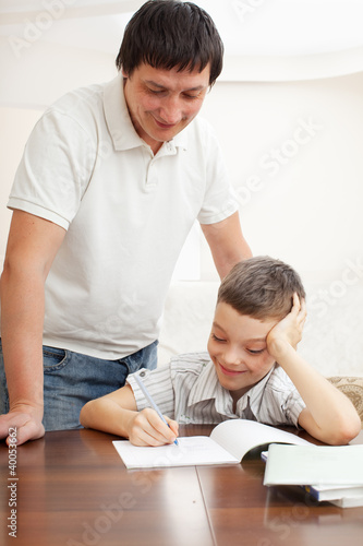 Photo: Father helping son do homework Father helping son do homework