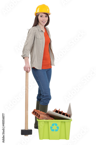 Photo: Female construction worker recycling old material Female construction worker recycling old material