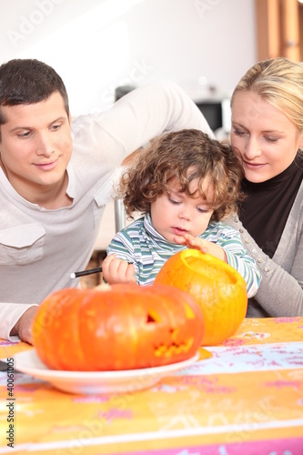 Photo: Parents and daughter in the kitchen preparing pumpkin Parents and daughter in the kitchen preparing pumpkin