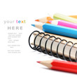 Photo: Colorful pencils and notebook isolated over white Colorful pencils and notebook isolated over white