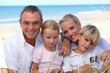 two parents and their two children in front of the sea