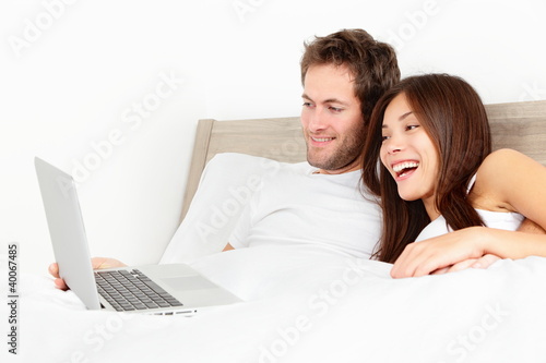 Photo: Couple with laptop in bed Couple with laptop in bed