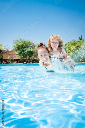 Photo: Happy child playing with mother in pool Happy child playing with mother in pool